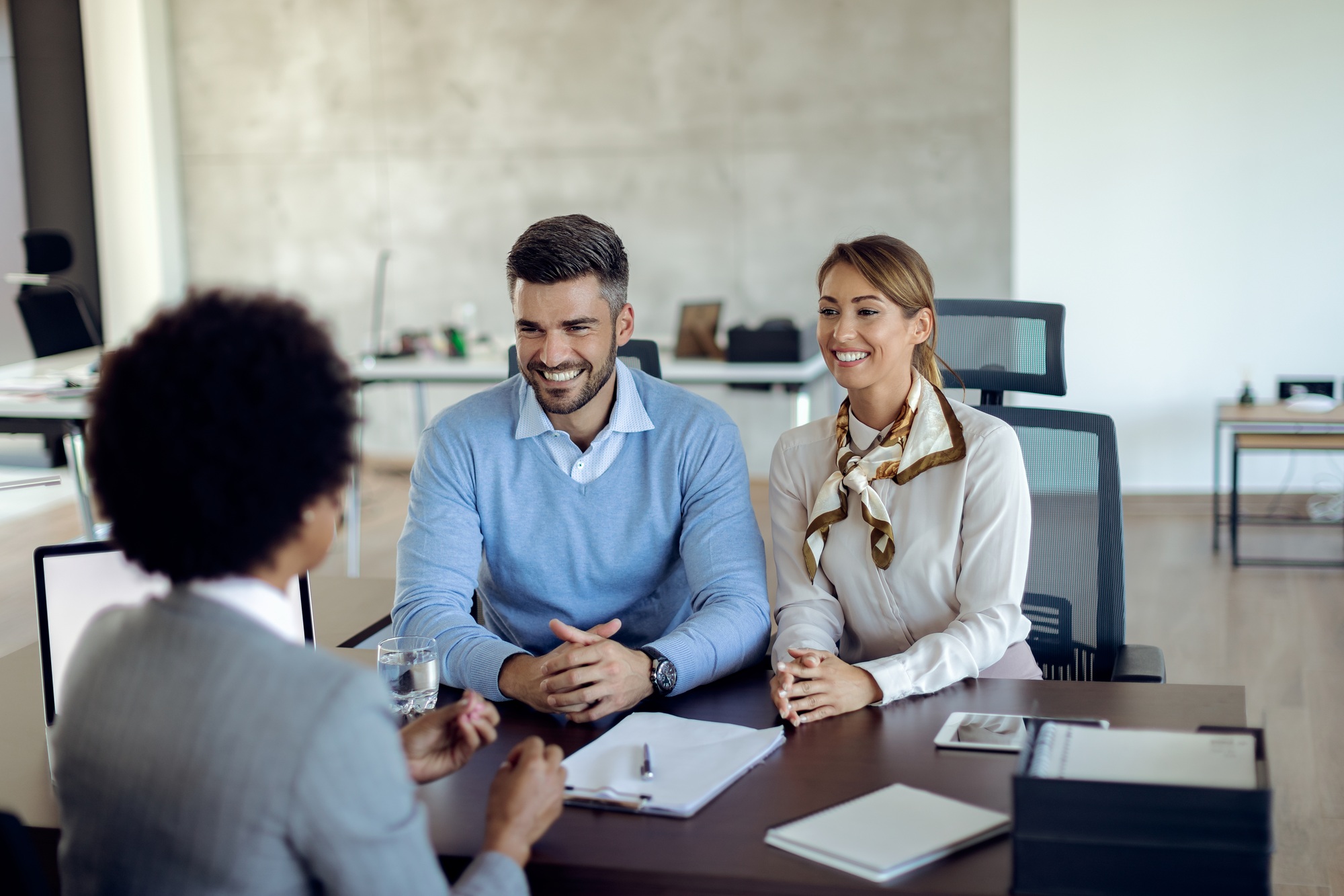 Happy couple communicating with financial consultant on a meeting in the office.